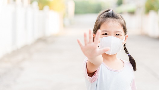 Image of little girl wearing mask holding up five fingers