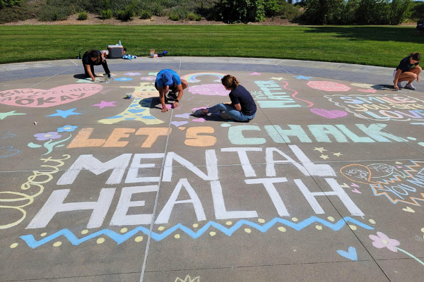Photo of volunteers drawing chalk art on sidewalk