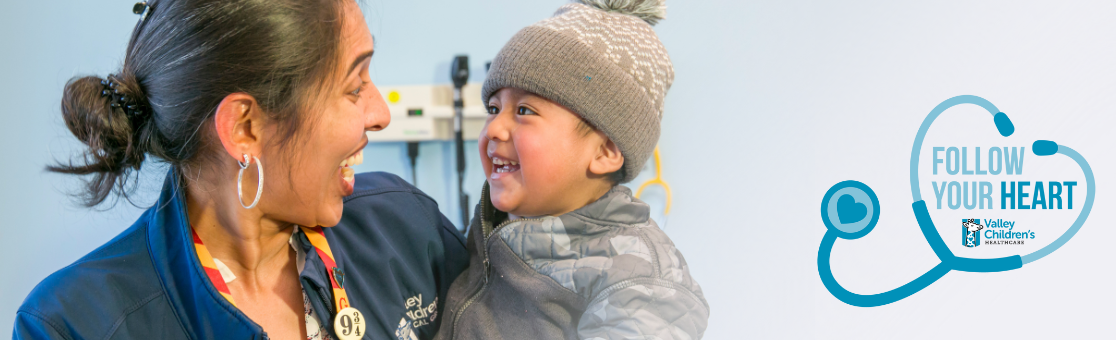 Female doctor smiling at a young patient who smiles back