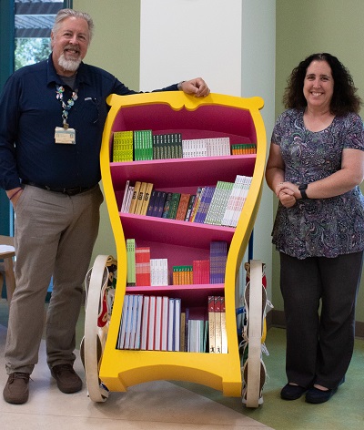 Foto de los bibliotecarios médicos de <i>Valley Children's</i> delante del carrito del <i>George's Book Club</i>