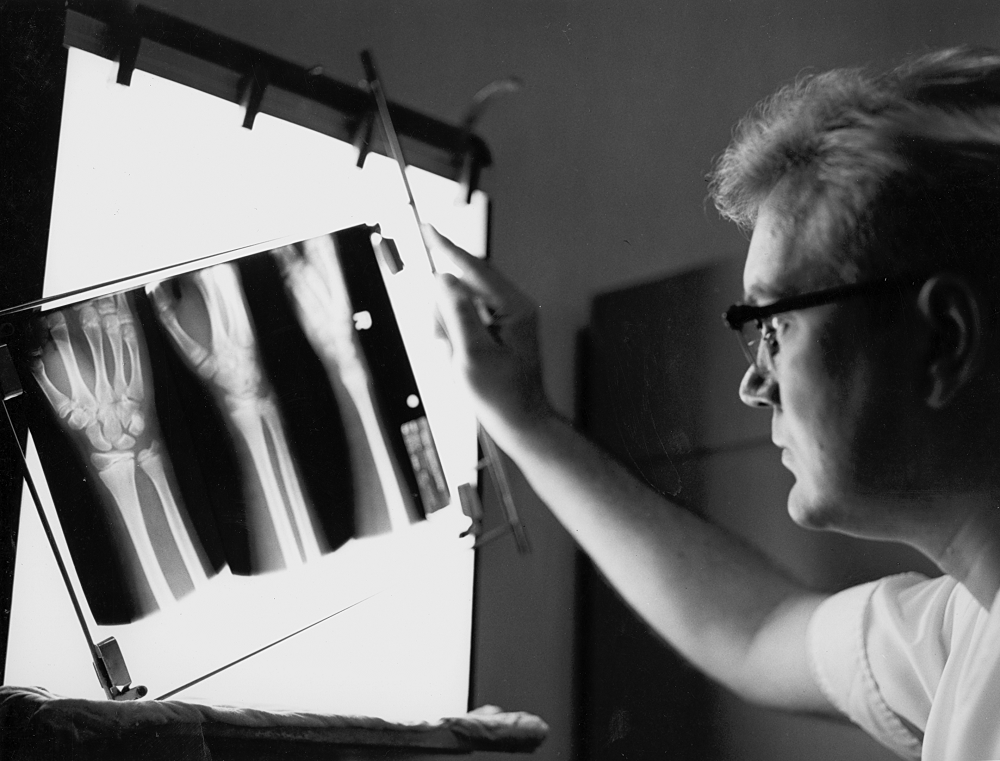 Um médico examina una radiografía de muñeca