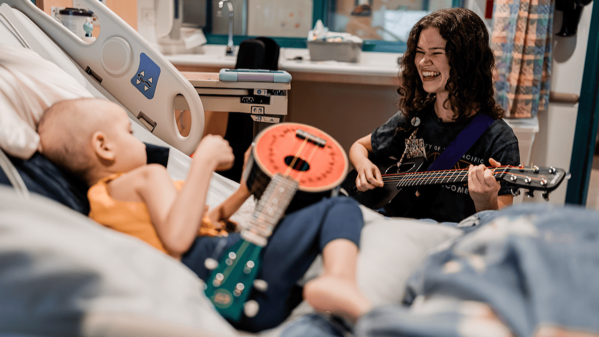 Child Life specialist playing music with a patient