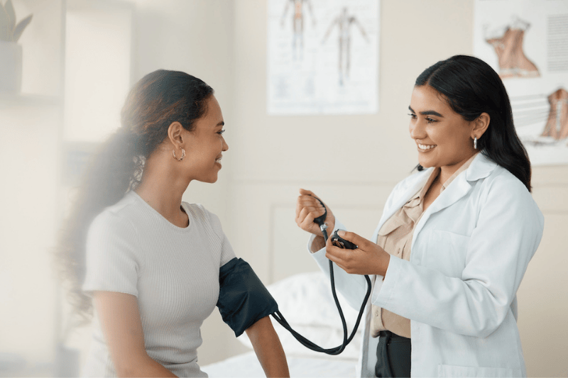 A doctor takes a female patient's blood pressure