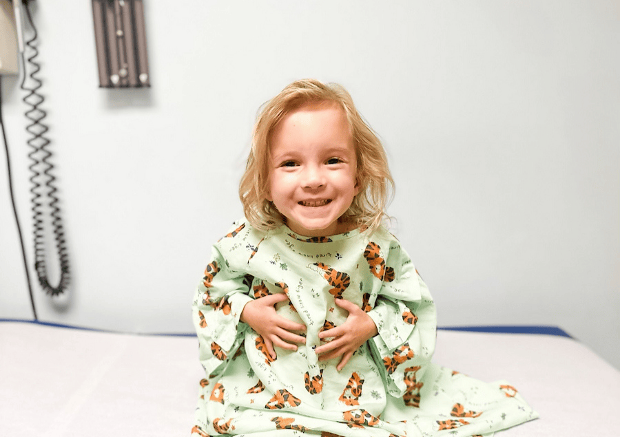 Una niña pequeña en la camilla del consultorio de un médico