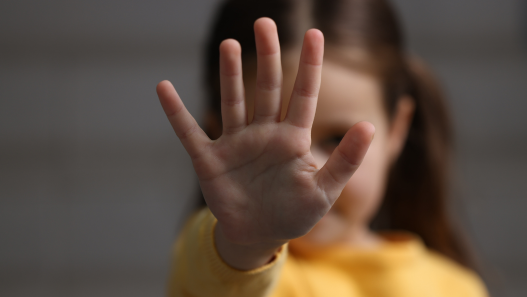 Niña extiende su mano hacia la cámara