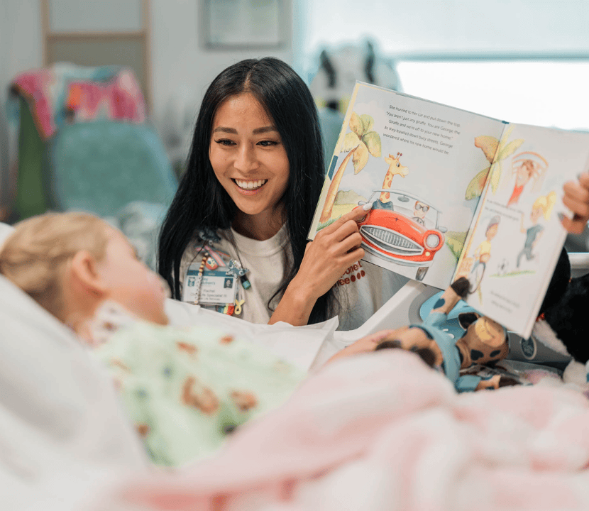 Un especialista en vida hospitalaria infantil de Valley Children's lee a un paciente joven