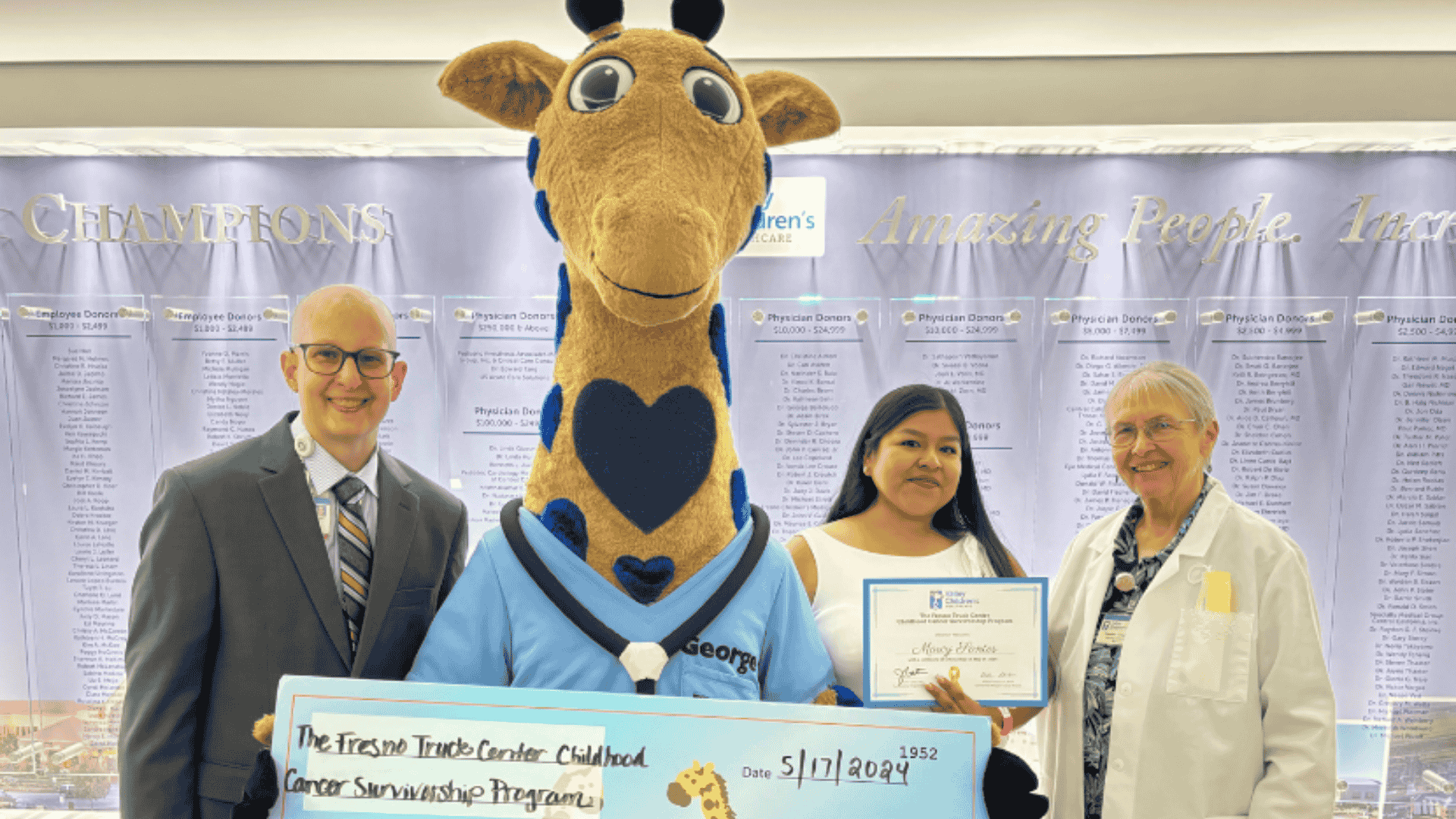 Marcy poses for a scholarship presentation with pediatric oncologists Drs. John Gates and Vonda Crouse
