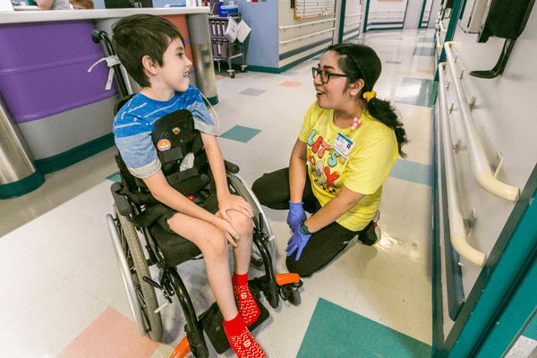 A young boy and a nurse talk