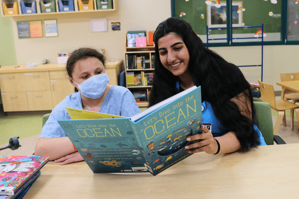 Un voluntario de Valley Children's lee con un paciente joven