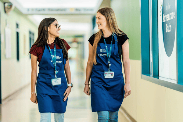 Two volunteers walk down a hallway together at Valley Children's Hospital