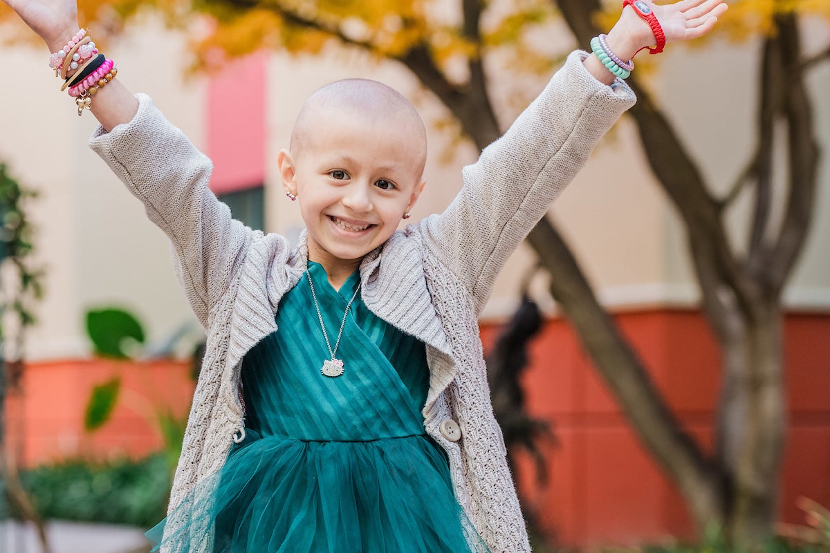 Radiotón: Abigail, una niña con un vestido verde, sonríe