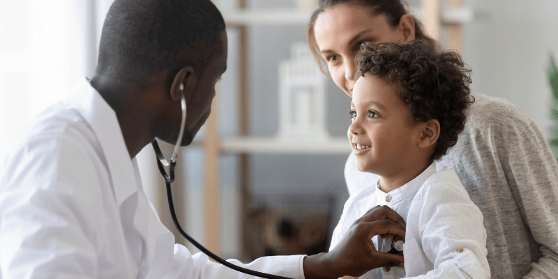 A doctor examines a young patient with a stethoscope