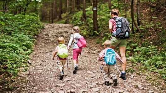 Children and adult hiking through the woods