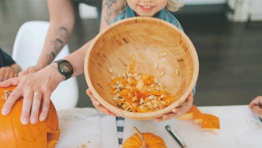 Child holding bowl of pumpkin seeds