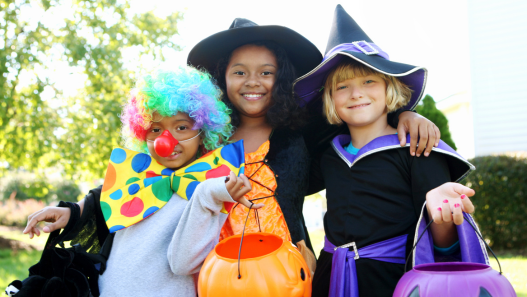 Children in Halloween costumes smiling