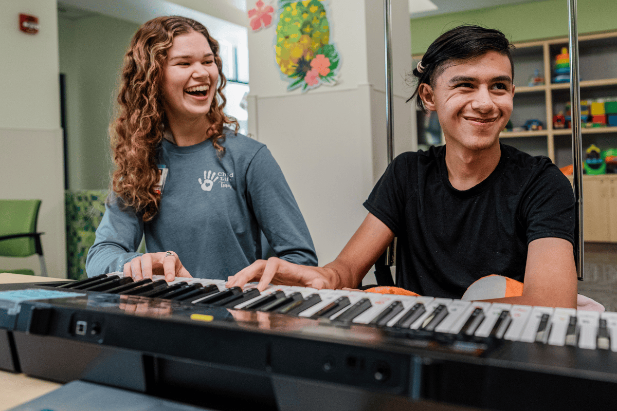 Valley Children's music therapist plays piano with a patient