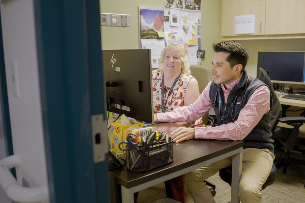 El Dr. David Tomajan y Sharon VanderPlaats, NP, revisan la información en una computadora