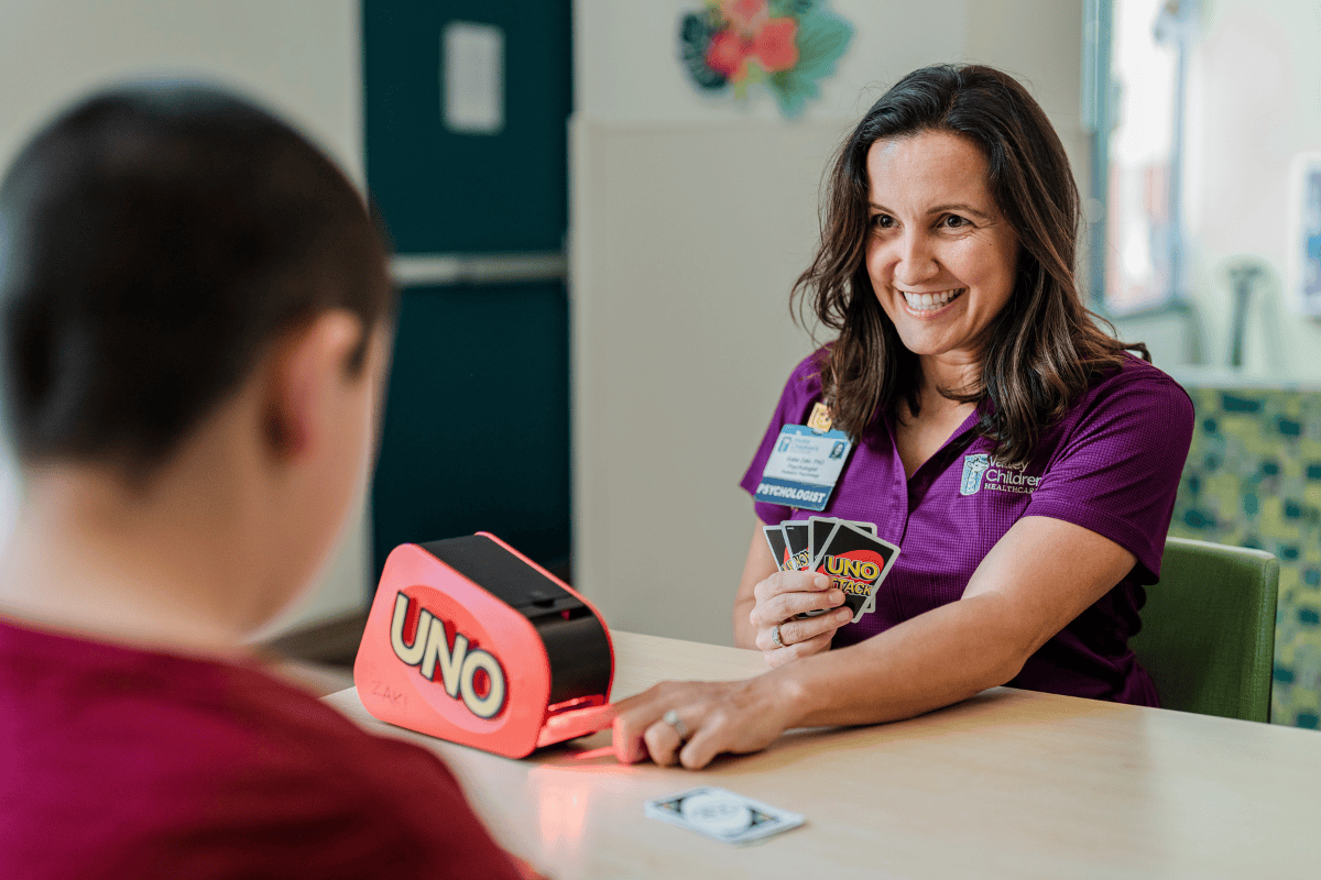La Dra. Katie Zaki, psicóloga de Valley Children's, juega al Uno con un paciente