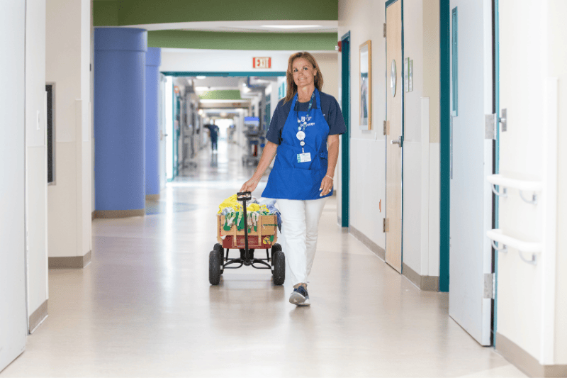A volunteer pulls a young patient in a wagon