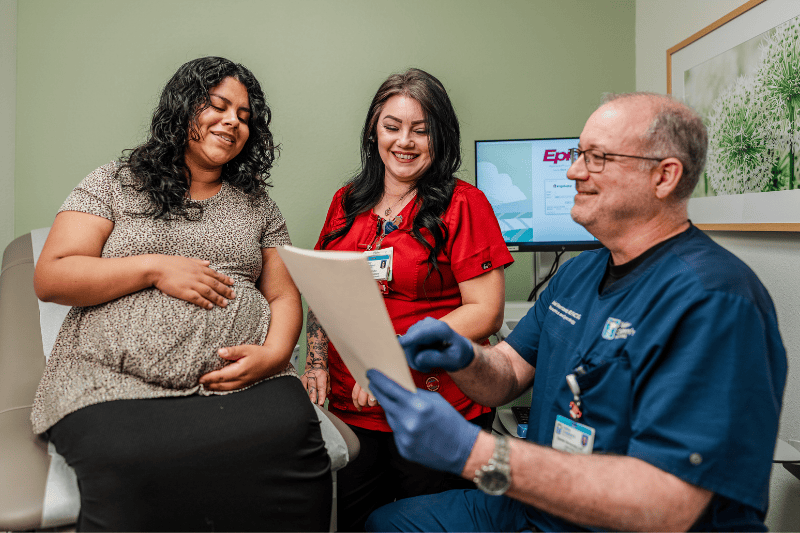 Dr. Hernandez and staff talk with a woman in clinic