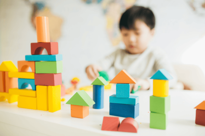 A young boy plays with colored blocks