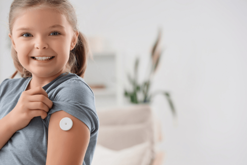 A young girl shows a glucose monitor