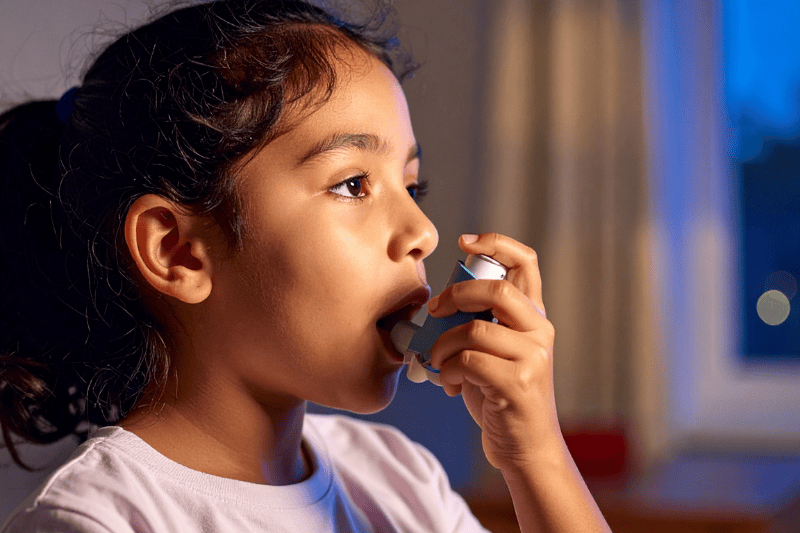 A young girl uses an inhaler