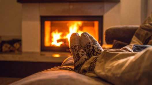 Feet propped up on couch by fireplace