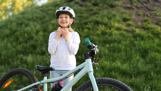 Child putting on a bike helmet