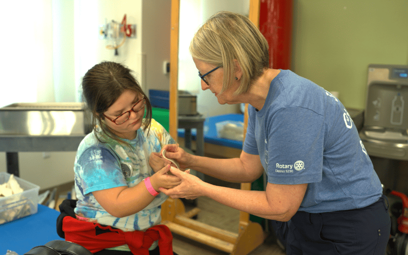 A teenage girl works with an occupational therapist