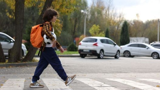 Boy crossing a crosswalk on the way to school