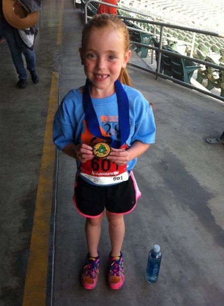 Kara smiles with a finisher's medal after a race