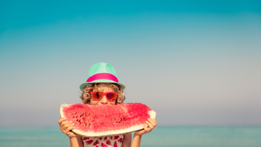 Child Holding a watermelon at the beach
