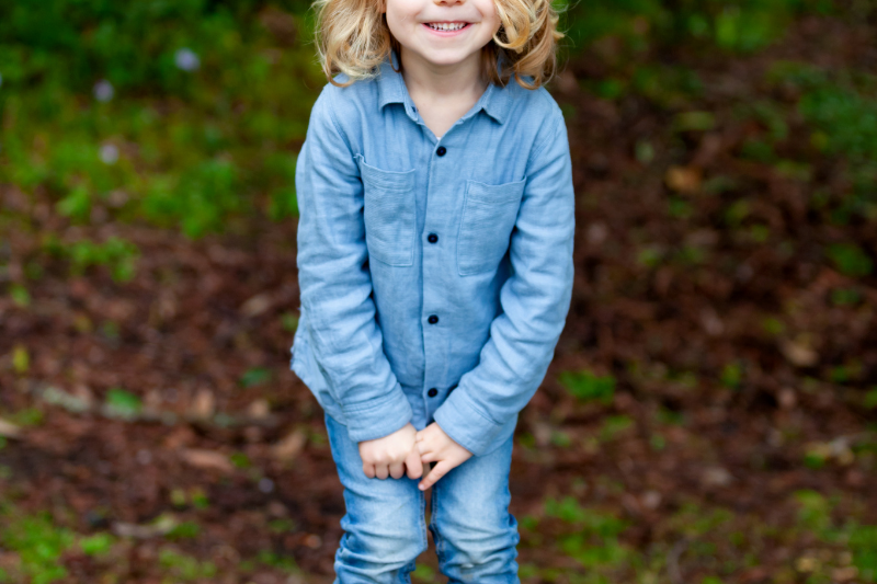 A young girl stands outdoors.