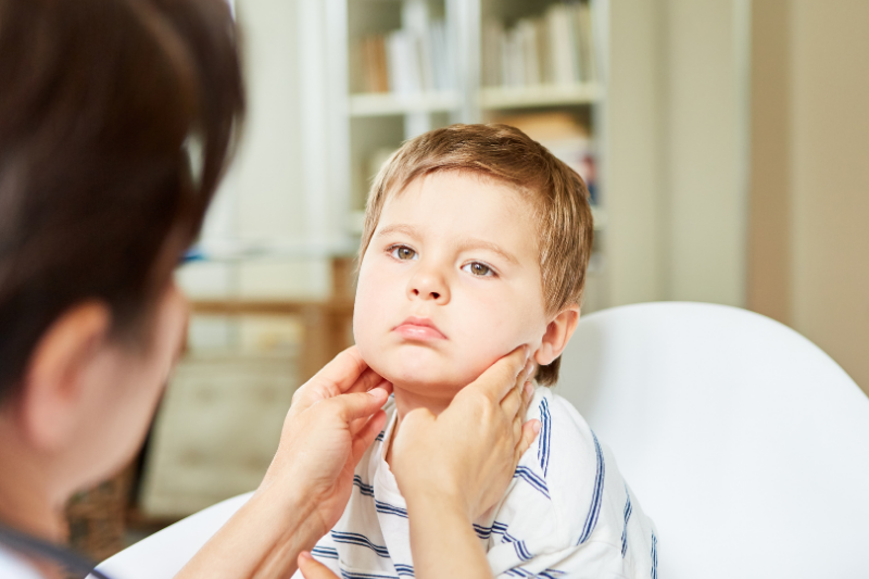 A doctor examines a child's lymph nodes in neck
