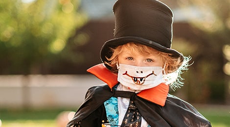 Niño con mascarilla vestido con un disfraz de Halloween