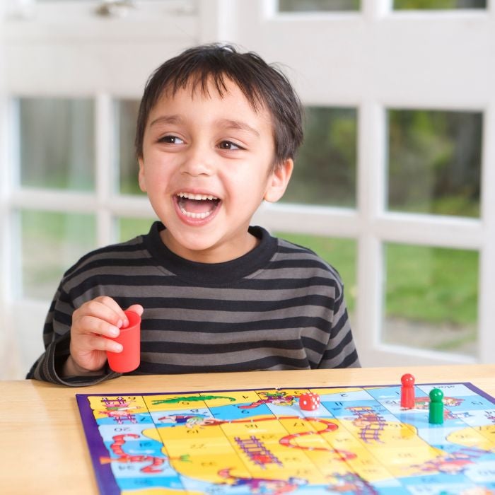 Child playing a board game smiling