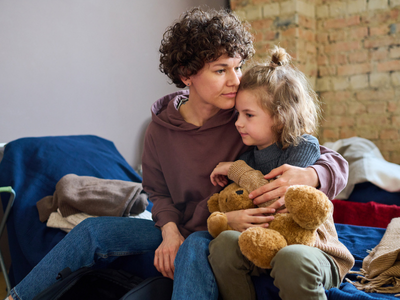 A young girl and her mother hug