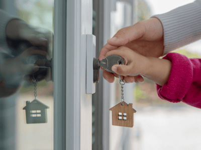 An adult and child unlock a door together