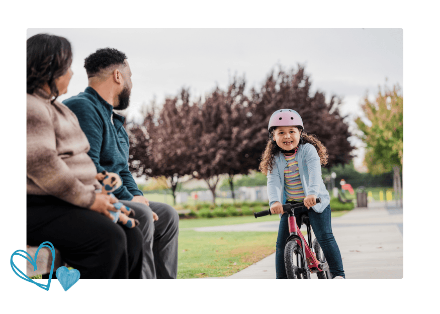 Avie smiles as she rides a bike