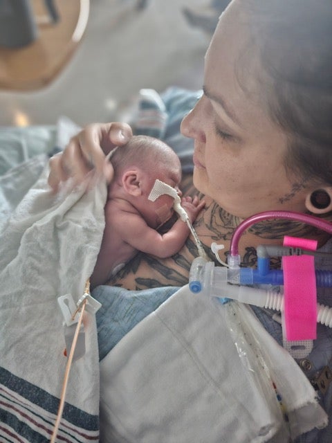 A woman nurses an infant child