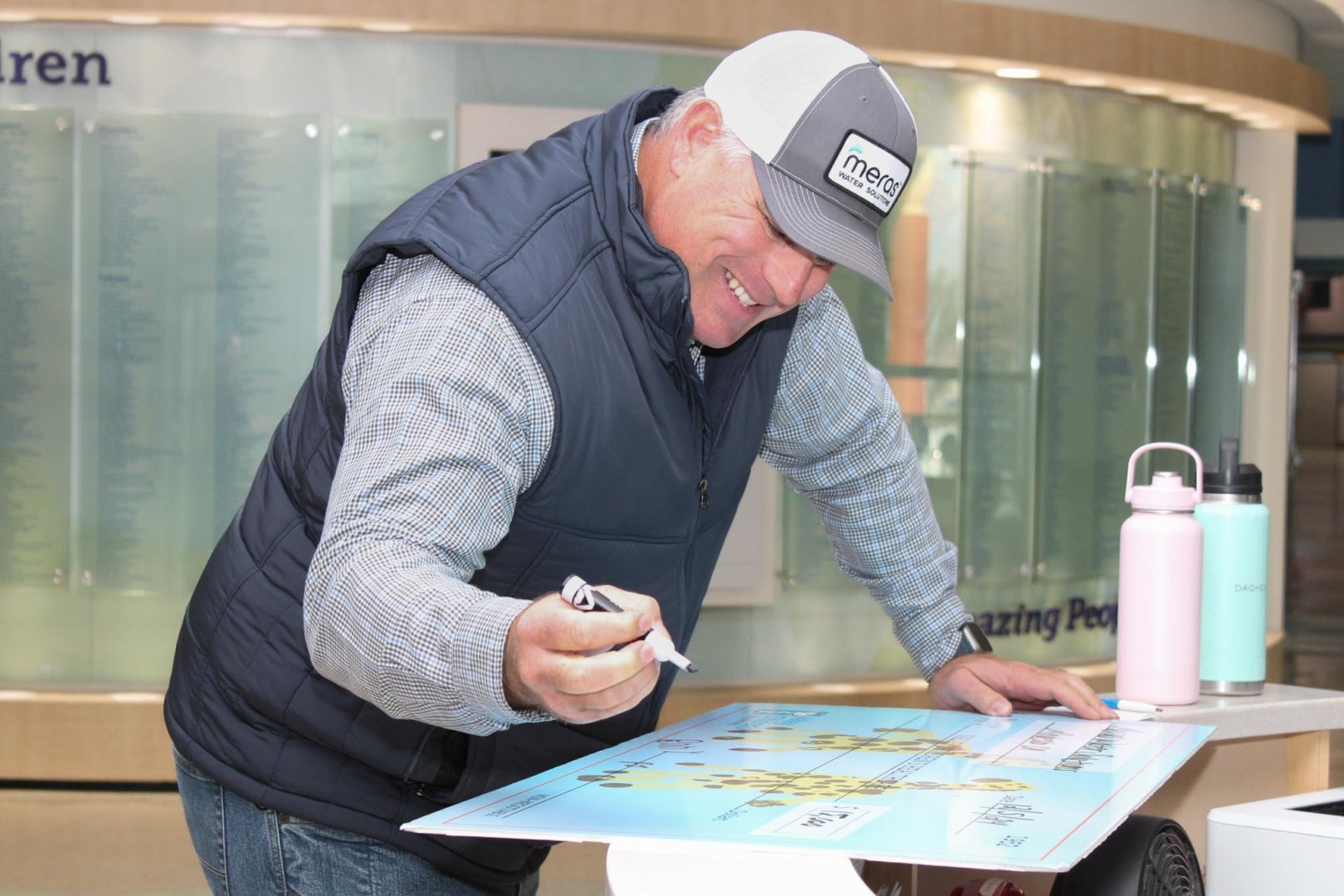 smiling man signs an oversized check