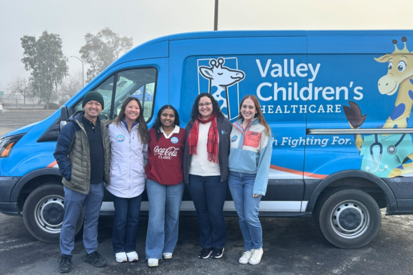 Pediatric Residents smile at a car seat safety event