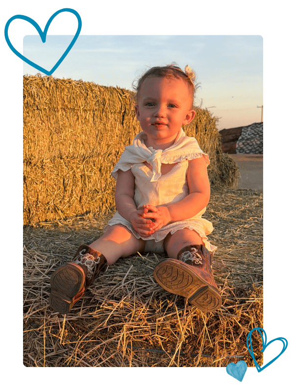 Scotti Jo sits on a haybale at sunset